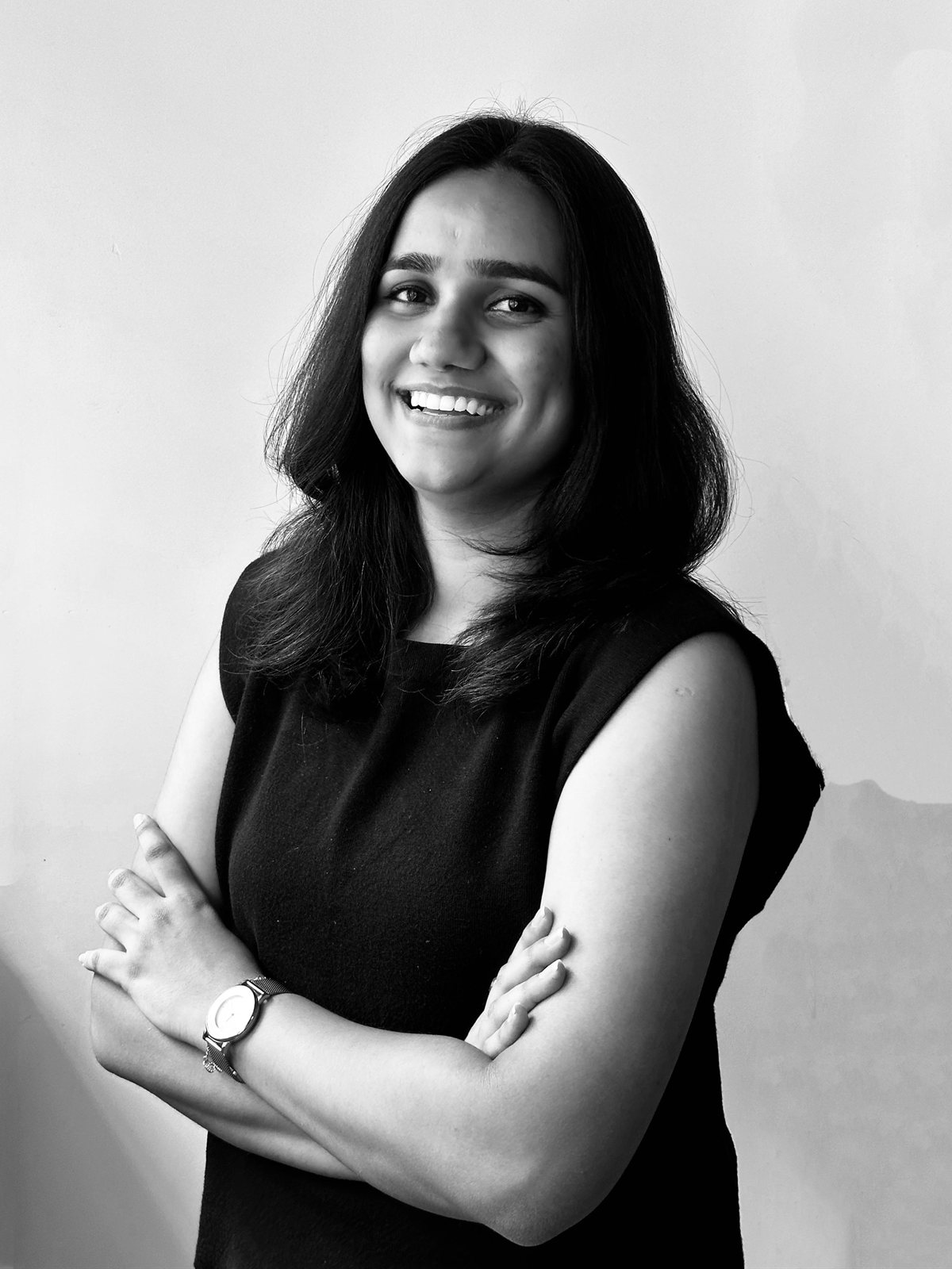 Portrait of Palak Joshi, smiling, arms crossed, in black and white